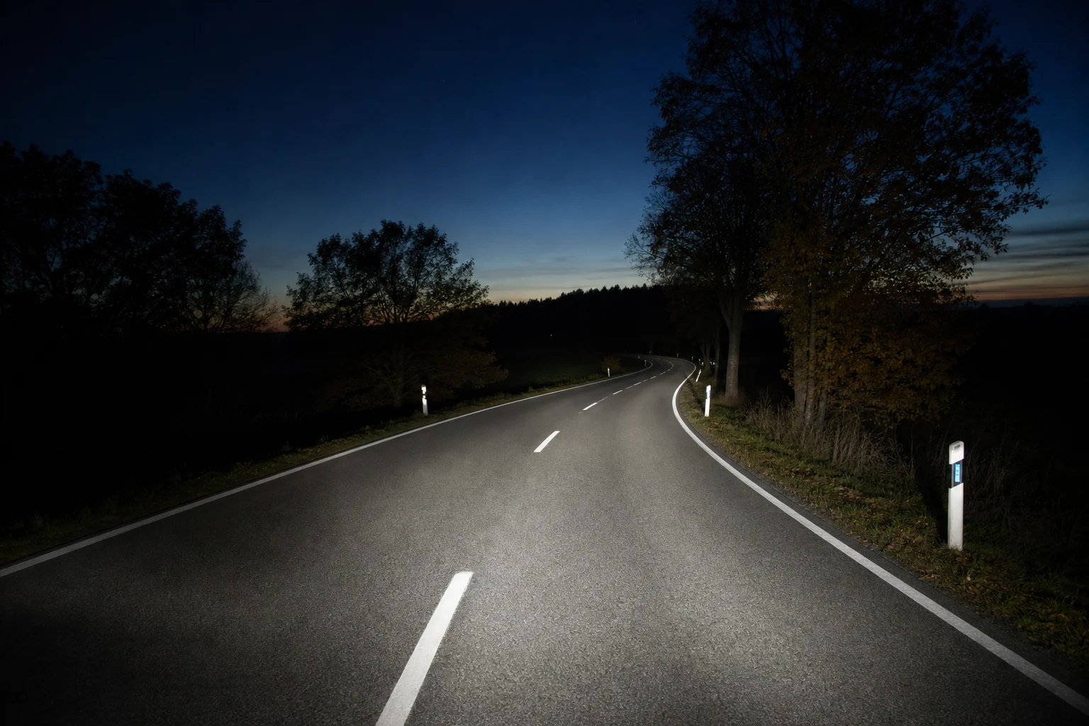 Estrada noturna iluminada por um feixe de médios